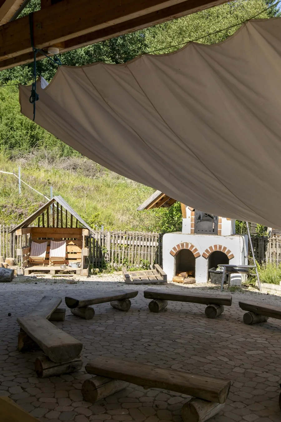 Backhaus und Spielhütte der Wiesengruppe unter einem großen Sonnensegel