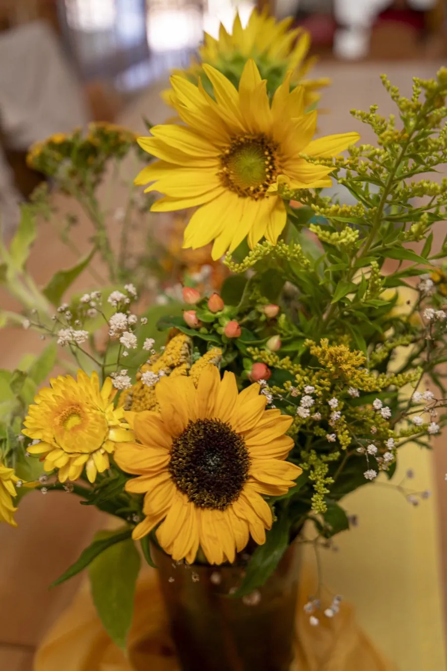 Strauß aus Sonnenblumen und Wiesenblumen auf dem Tisch der Kinderstube