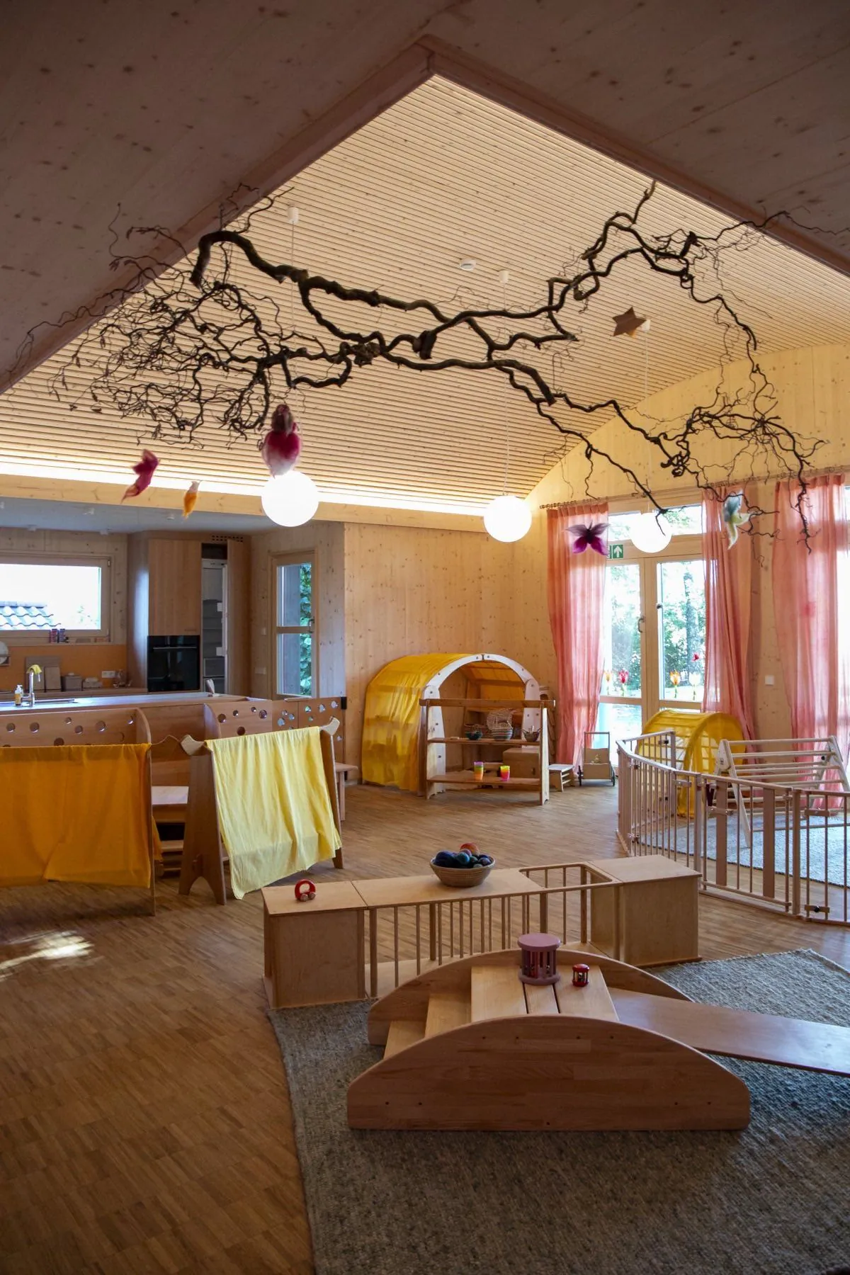 Offener Wohn- und Küchenbereich mit Astdekoration in der Waldorfkrippe Großdeinbach