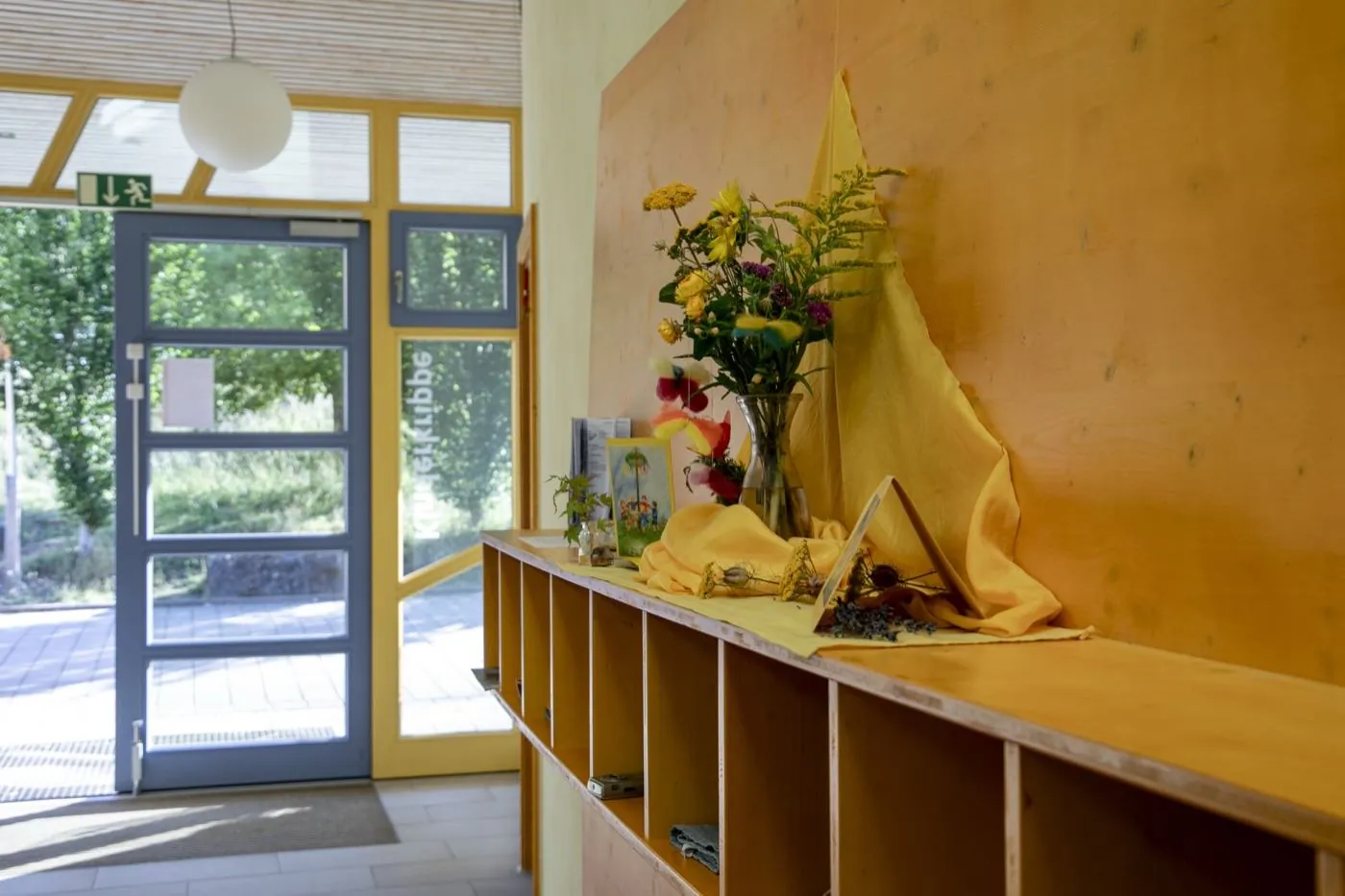 Eingangsbereich der Kinderstube mit Jahreszeiten-Tisch und Garderobe