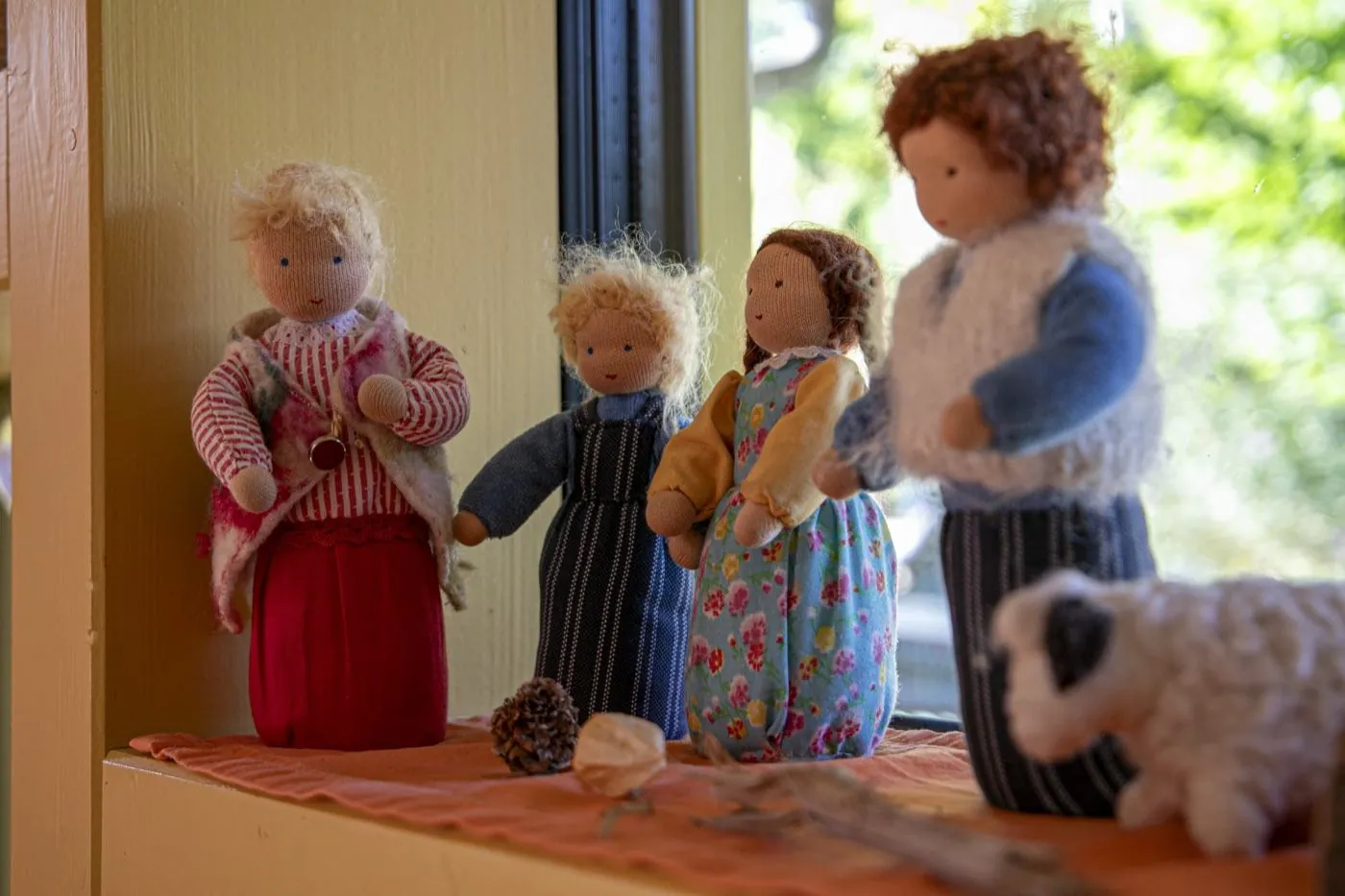 Waldorfpuppen auf einer sonnigen Fensterbank in der Kinderstube