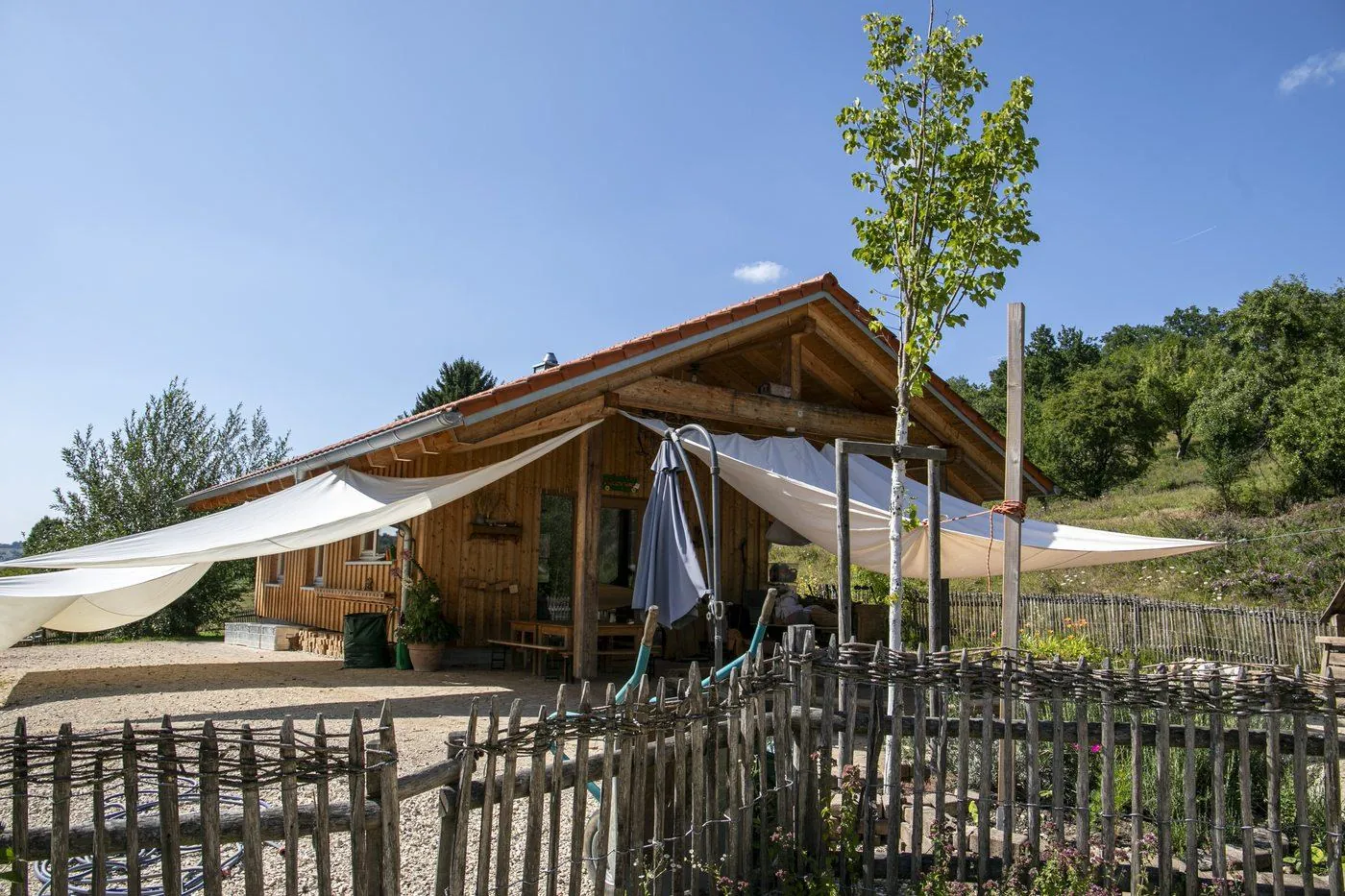 Wiesengruppe, Holzhütte mit Sonnensegeln auf dem Wiesengelände
