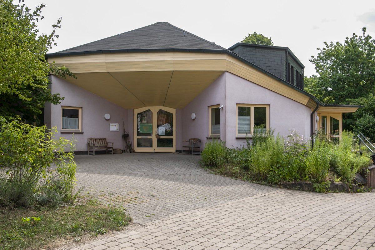 Der offene Eingangsbereich des Waldorfkindergartens mit Bänken unter dem Vordach